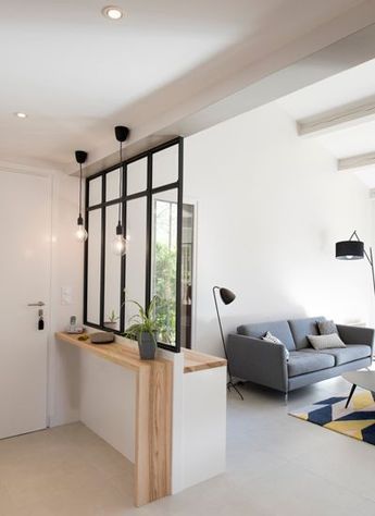 Entrée ouverte sur salon et délimitée grâce à une verrière atelier