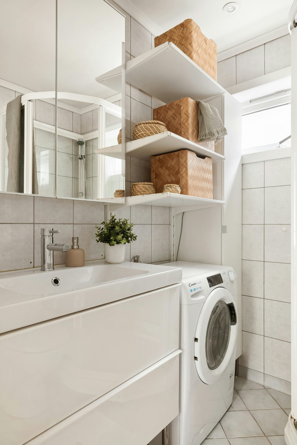 Etagères murales installées dans la salle de bain pour utiliser l'espace disponible au dessus de la machine à laver : l'astuce du rangement vertical